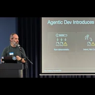 Man standing at podium presenting slide on Agentic Development