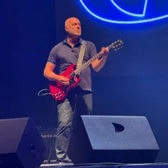 Steve Mason with a red electric guitar.