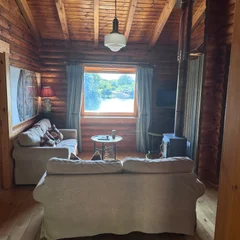 View of the lake from inside a log cabin