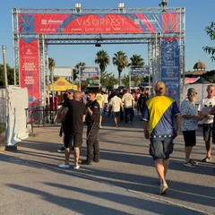 Middle-aged indie fans walking through an arch with the words "Visorfest" above them.